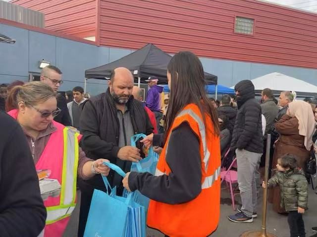 Volunteers distributing grocery bags to families at the pantry